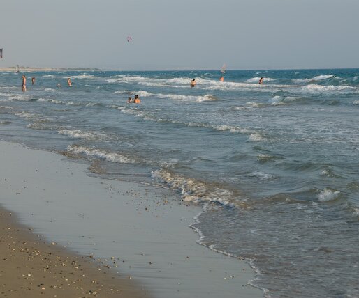 _DSC0054 Kourion beach with swimmers, paragliders and surfers.