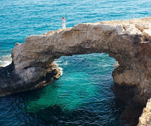 _DSC0041 Markos standing on the natural bridge, over the clear waters at the sea caves area.