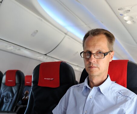 _DSC0032 Arto reading the newspaper on the iPad on the flight to Sweden.