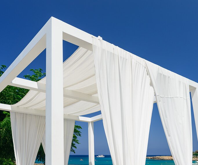 _DSC0026-2 At the loungers at Capo Bay Hotel . The clear blue waters of the Mediterranean at Fig Tree Bay in the background.